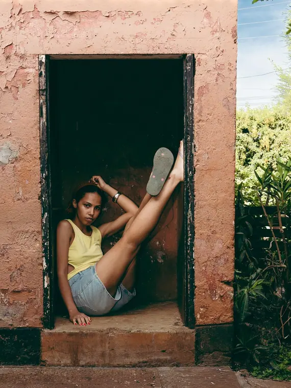 Styled portrait against a painted wall in Kibera, from the Still Here series
