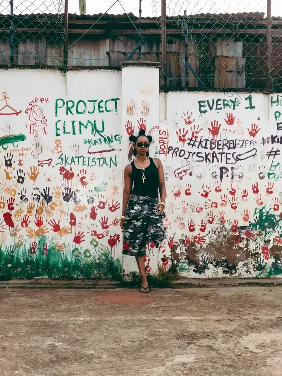 Styled portrait against a painted wall in Kibera, from the Still Here series
